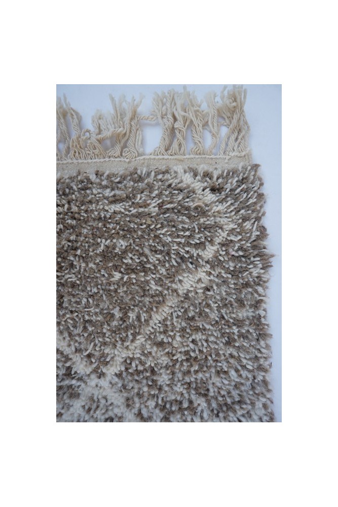 Tapis berbère en couleurs beige et marron avec un motif géométrique texturé et des franges.