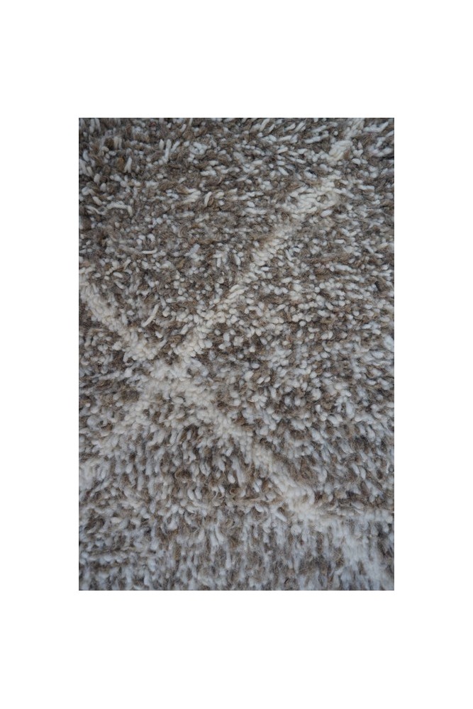 Tapis berbère en laine beige et blanc avec motifs géométriques doux, parfait pour un intérieur chaleureux et élégant.