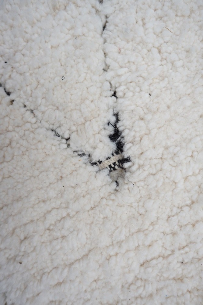 Tapis berbère au style moderne, aux couleurs blanc et noir avec des motifs géométriques stylisés.