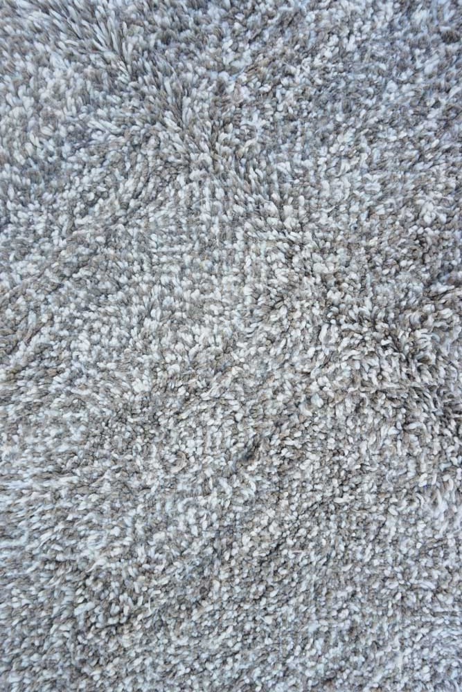 Tapis berbère doux aux tons gris naturels, avec des motifs texturés élégants pour une ambiance chaleureuse.