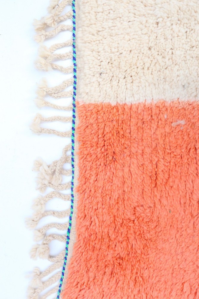 Teppich, getuftet im modernen Stil, in Korallenorange und Cremefarben, mit zweifarbiger Gestaltung mit Fransen.

Ein Teppich im 