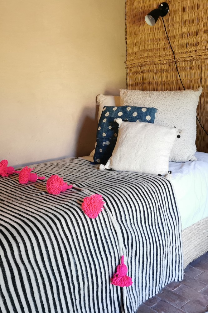 Manta de cuadros blancos y negros con borlas rosas de lana hecha a mano en Marruecos.