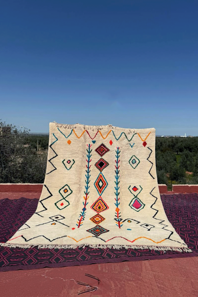 Gran alfombra bereber Azilal blanca con rombos y zigzags en rosa, verde, azul y amarillo.