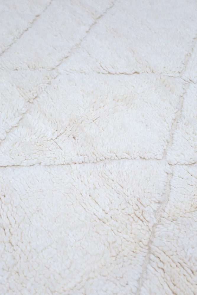 Tapis berbère en laine, couleur crème, motifs géométriques modernes, parfait pour une décoration chaleureuse et élégante.