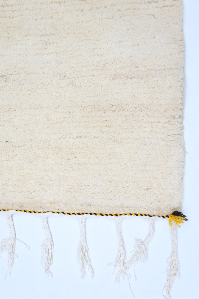 Tapis berbère beige avec motifs discrets et franges bohèmes pour une ambiance chaleureuse et naturelle.