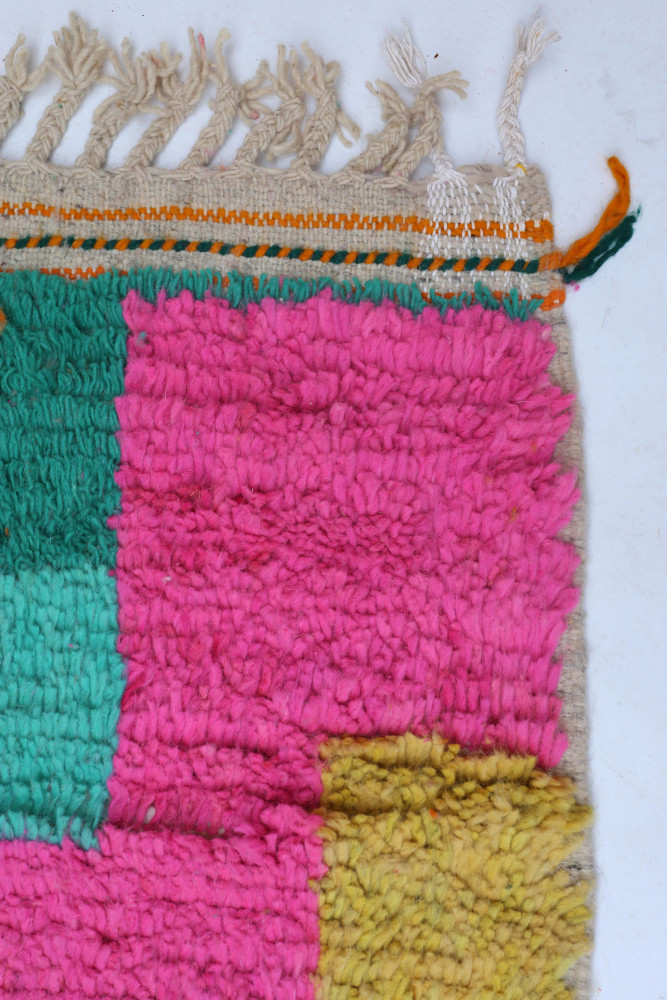 Tapis berbère aux couleurs vives avec des motifs en rose, vert et jaune, ajoutant une touche moderne à votre intérieur.