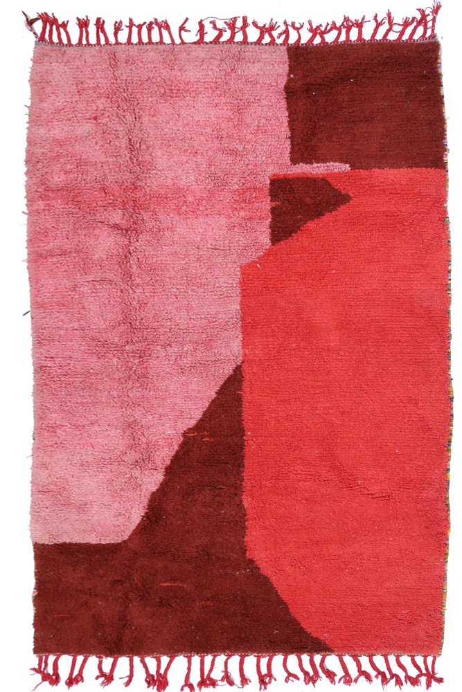 Tapis berbère aux teintes de rose et marron avec des motifs géométriques modernes et des franges décoratives.