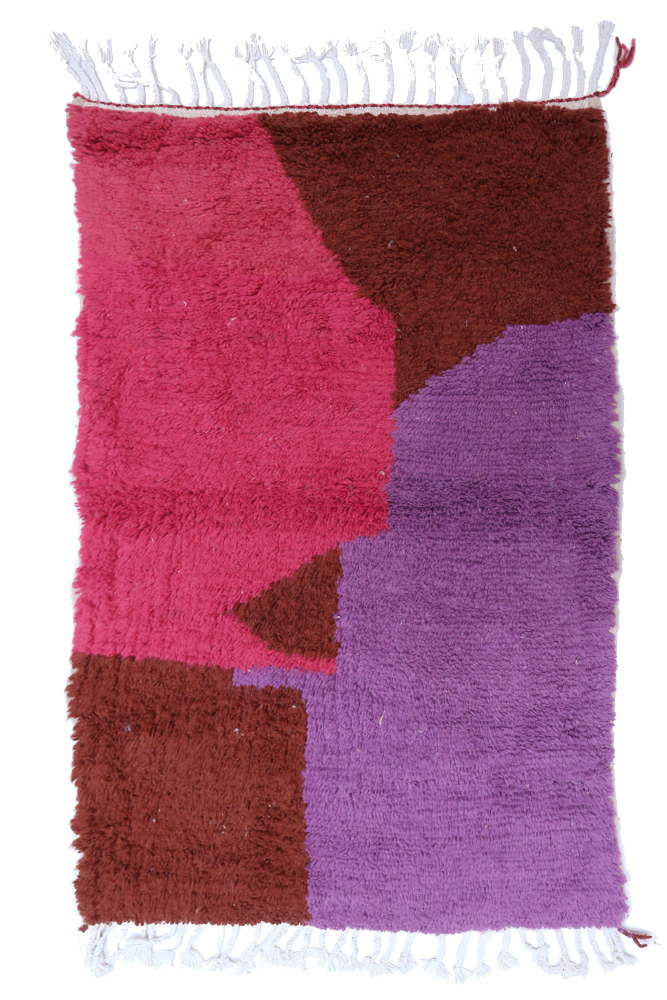 Tapis berbère aux motifs géométriques avec des couleurs vives de rose, violet et brun, ajoutant une touche moderne.