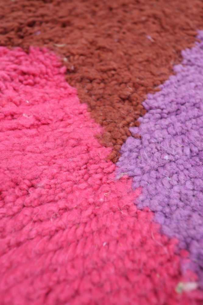 Tapis berbère aux couleurs vives de rose, violet et brun avec des motifs géométriques contemporains.