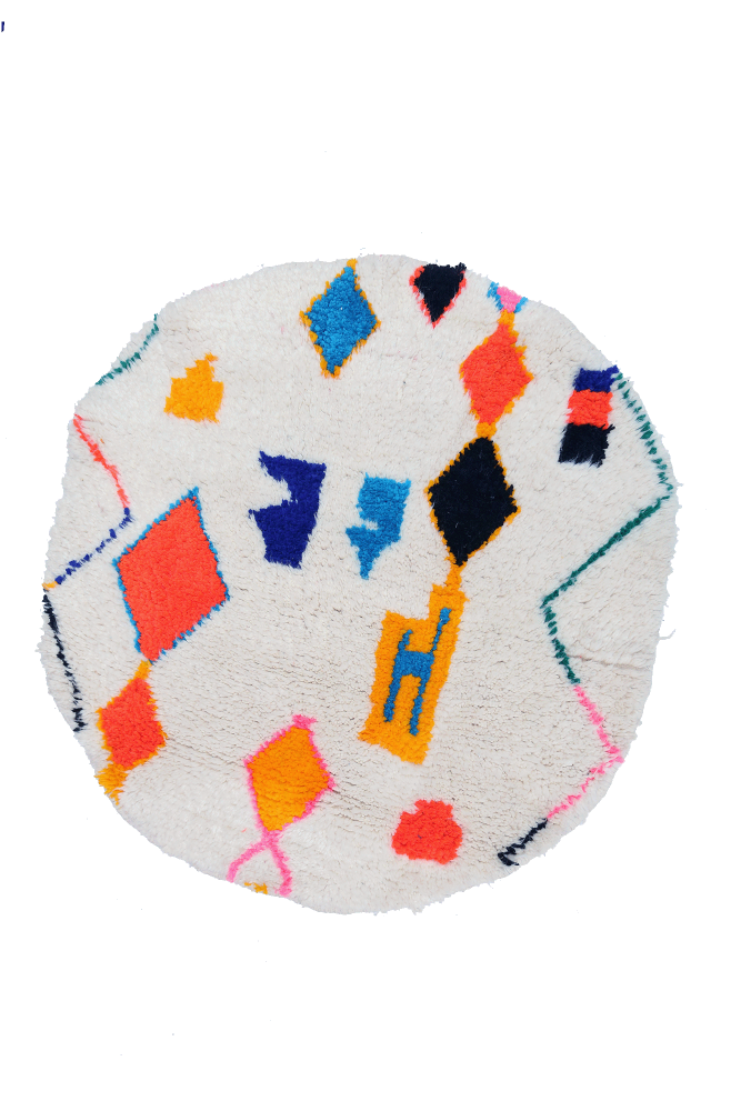 Tapis berbère rond aux couleurs vibrantes avec des motifs géométriques en orange, bleu, noir et rose sur fond crème.