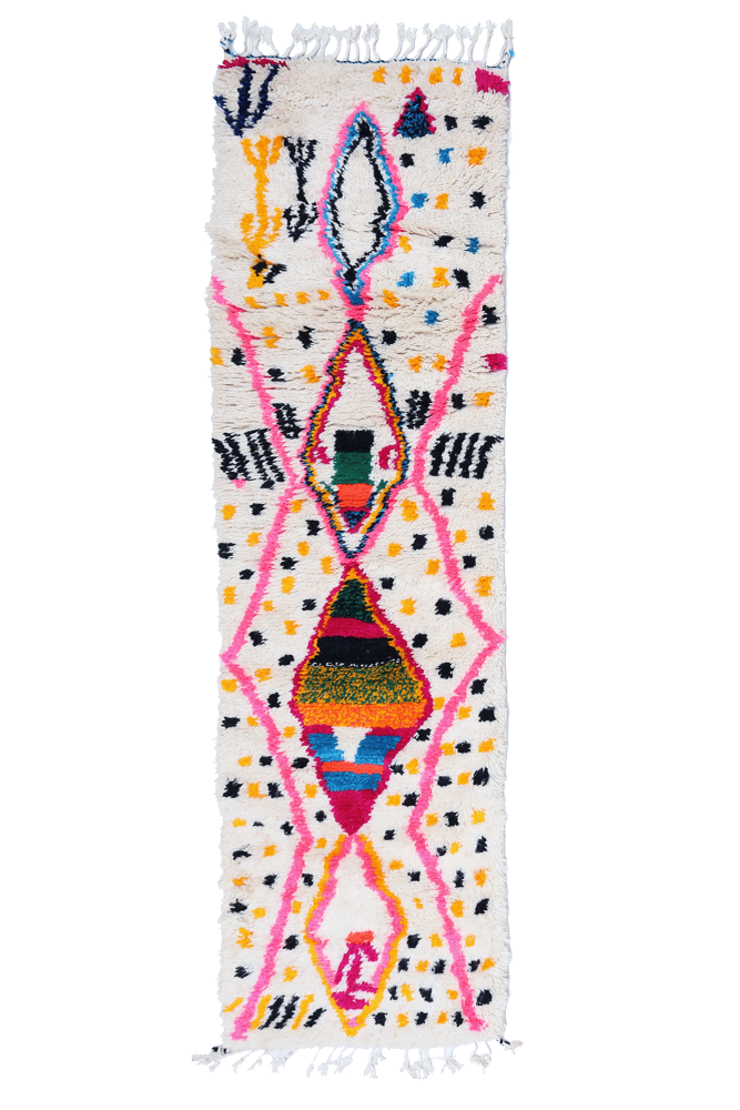 Tapis berbère coloré et contemporain avec des motifs géométriques en rose, bleu, jaune et noir sur fond blanc.