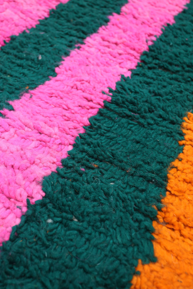Tapis berbère coloré avec des bandes roses, vertes et orange, offrant un style contemporain et vibrant.