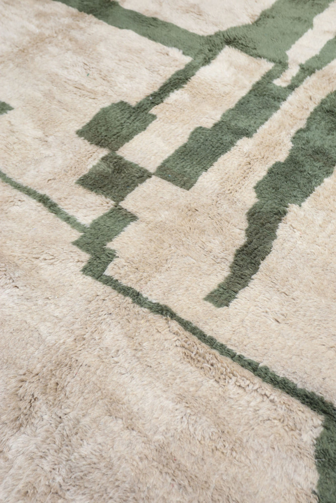 Tapis berbère aux motifs géométriques, beige et vert, offrant une touche moderne et chaleureuse à votre intérieur.