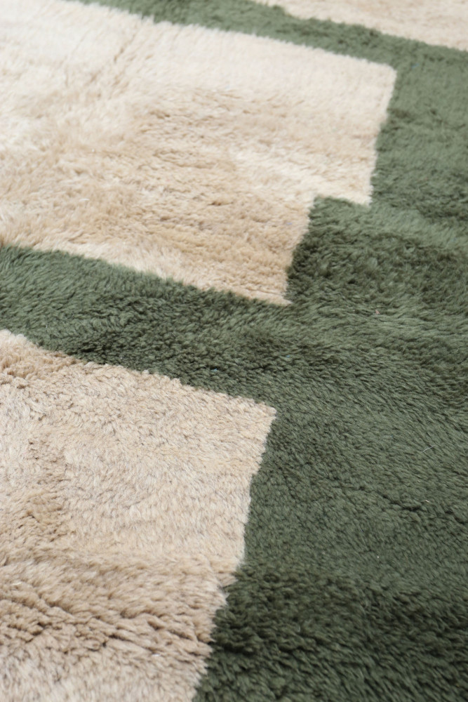 Tapis berbère avec des motifs géométriques en beige et vert, idéal pour une décoration moderne et chaleureuse.
