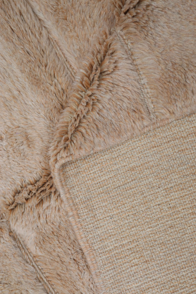 Tapis berbère doux en tons beige, avec un motif texturé et un design moderne et élégant.