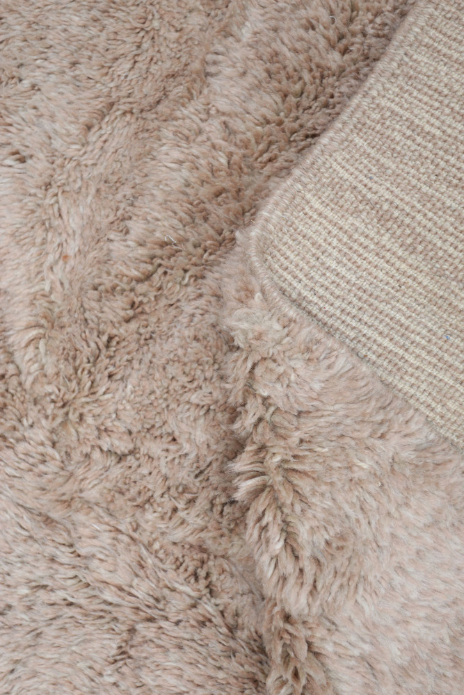 Tapis berbère doux en tons beige et crème avec un motif texturé, parfait pour un intérieur moderne et cosy.