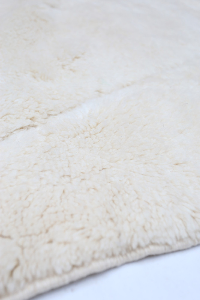 Tapis berbère beige au design minimaliste, à la texture douce et au motif subtil pour un intérieur chaleureux.