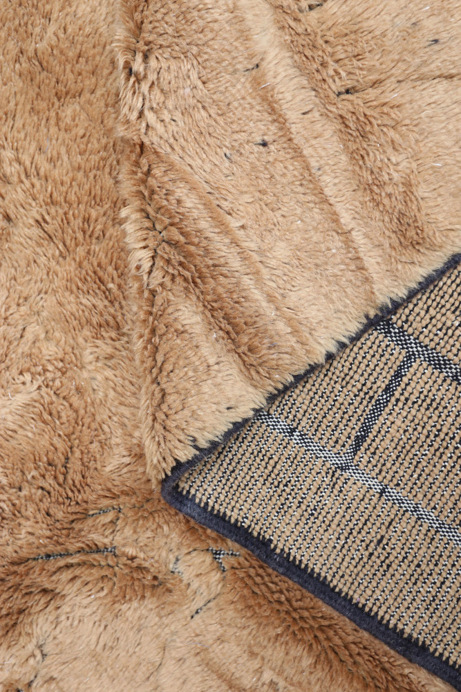 Tapis berbère doux aux teintes beige et motifs géométriques, apportant chaleur et style à votre intérieur.