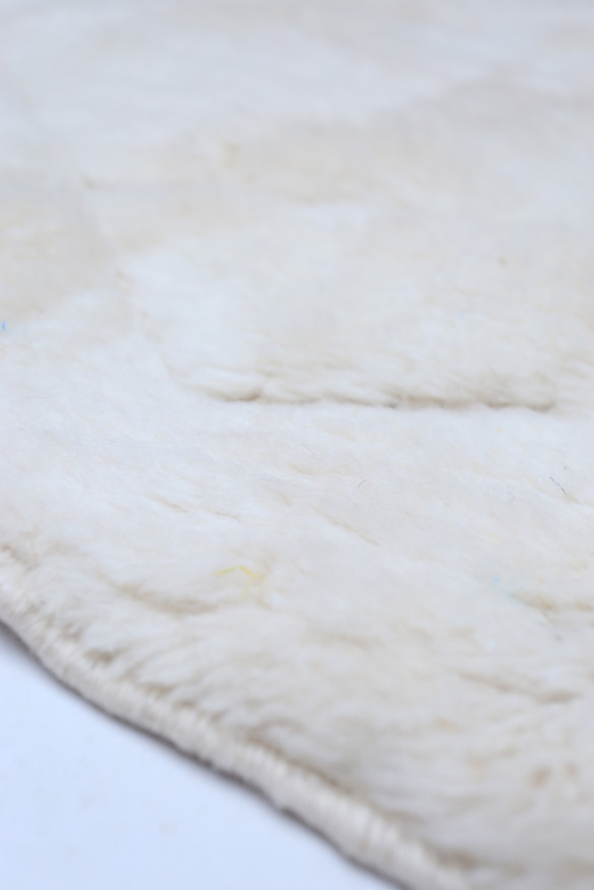 Tapis berbère en laine crème avec un motif géométrique subtil pour un style moderne et chaleureux.