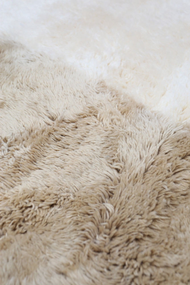 Tapis berbère en beige et crème, avec un motif doux et texturé, parfait pour un intérieur chaleureux et accueillant.