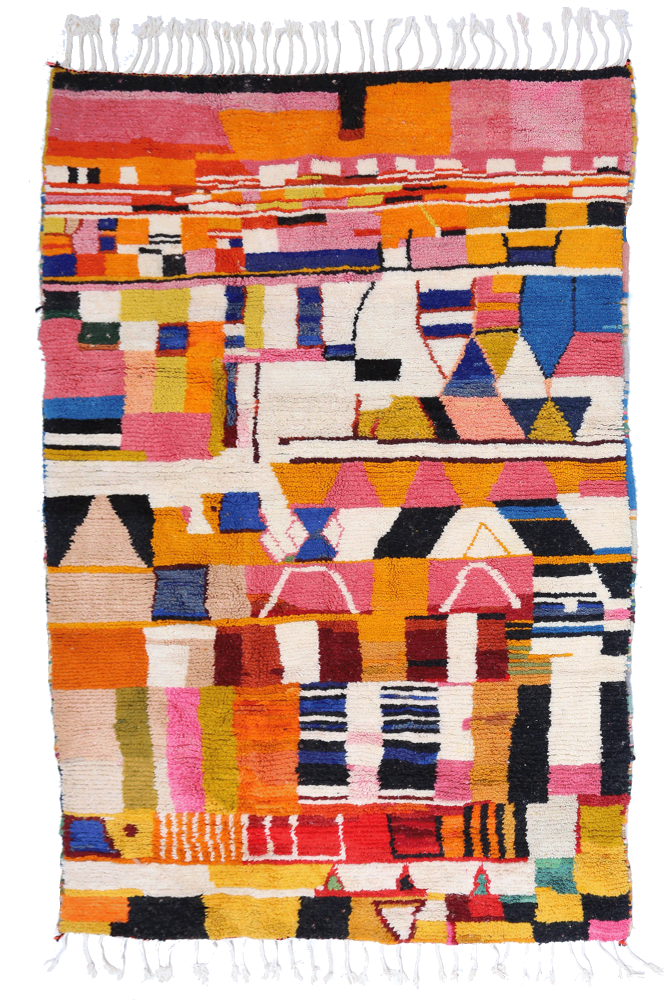 Tapis berbère coloré avec des motifs géométriques vifs en rose, bleu, jaune et noir, créant une ambiance chaleureuse et moderne.