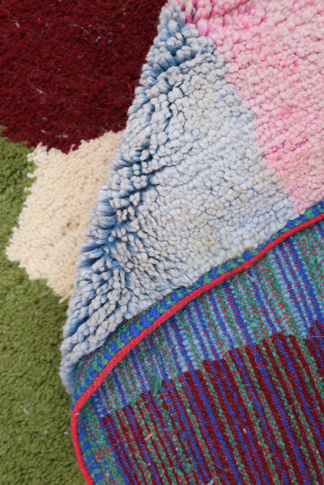 Tapis berbère aux motifs colorés avec des tons de bleu, rose, rouge et green créant un design contemporain.