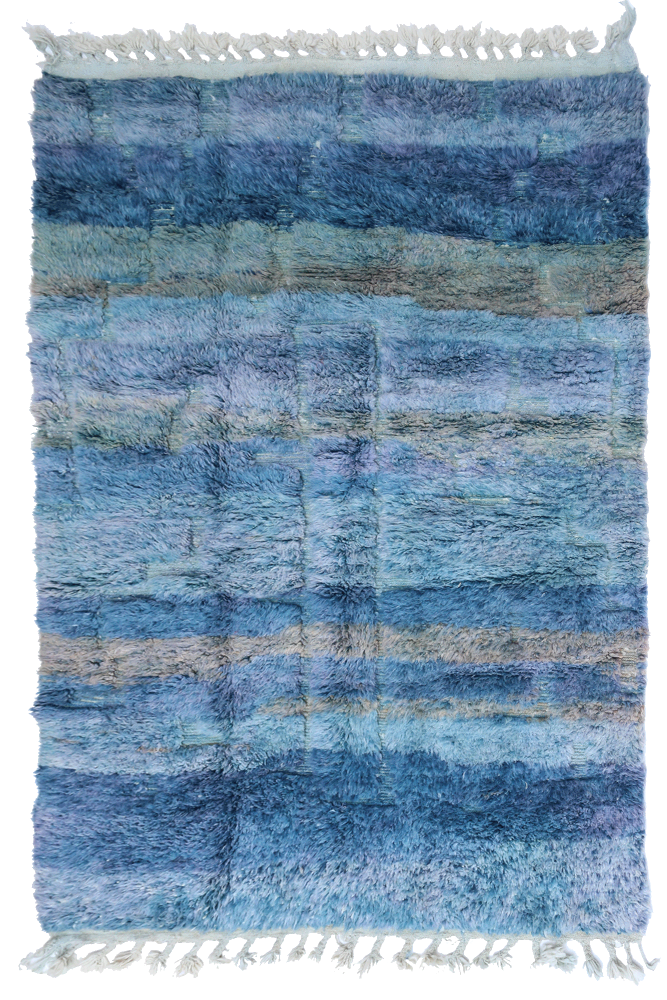 Tapis berbère bleu en dégradés avec des motifs rayés, idéal pour une décoration moderne et chaleureuse.