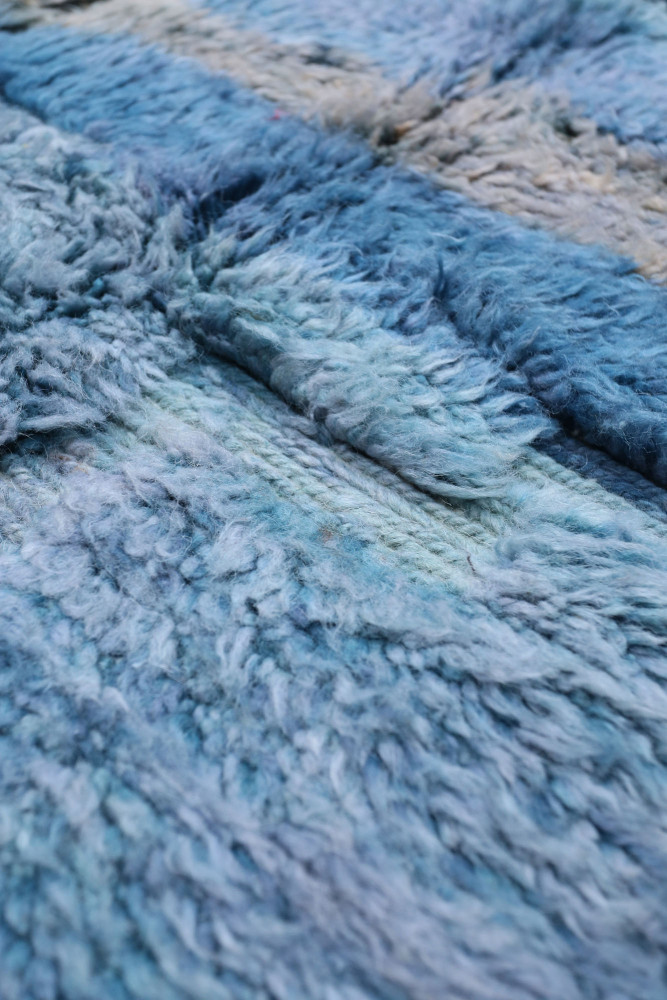 Tapis berbère en tons de bleu, avec des motifs doux et texturés, apportant une touche artisanale à votre intérieur.