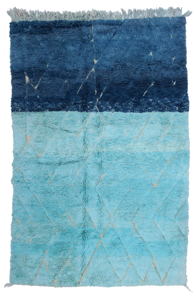 Tapis berbère en dégradé de bleu avec motifs en losanges sur fond clair, ajoutant une touche moderne à votre intérieur.