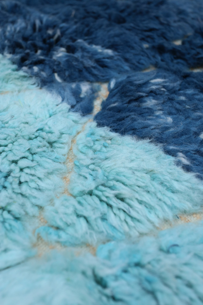 Tapis berbère en dégradé de bleu et turquoise, doté de motifs doux et texturés pour une ambiance chaleureuse.