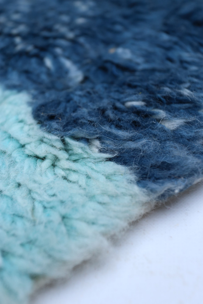 Tapis berbère en laine, dégradé de bleu marine à bleu clair avec des motifs texturés et modernes.
