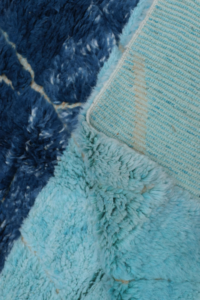 Tapis berbère aux teintes bleu turquoise et marine avec motifs géométriques modernes, apportant une touche élégante.