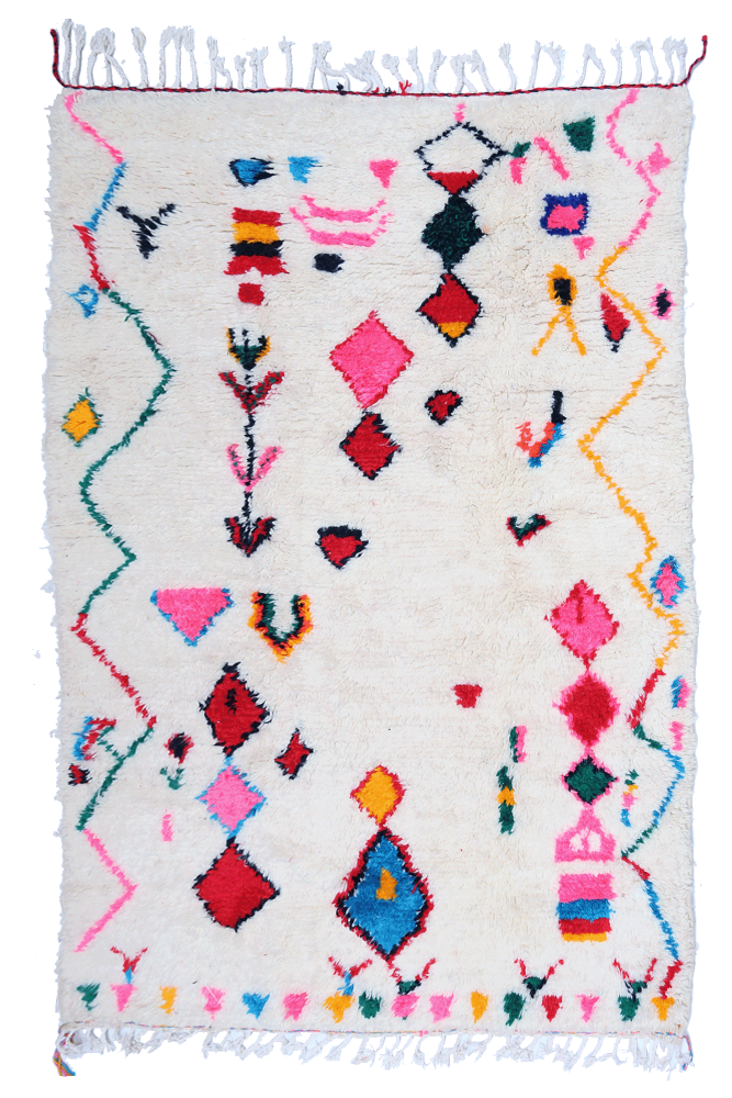 Tapis berbère en laine douce, motifs géométriques colorés sur fond crème avec des touches de rose, bleu et jaune.