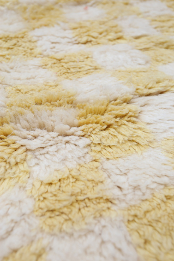 Tapis berbère jaune et blanc, motifs géométriques avec texture douce et volumineuse pour un style chaleureux et contemporain.