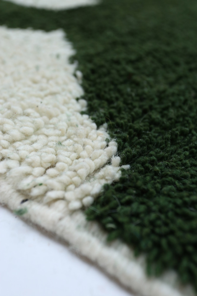 Tapis berbère vert et crème avec un design texturé et des motifs contemporains pour un intérieur moderne et chaleureux.