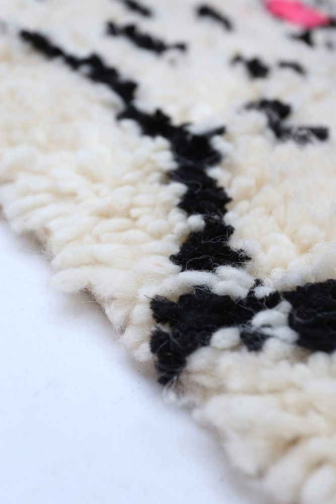 Tapis berbère au design moderne, couleur crème avec motifs noirs élégants et textures naturelles.