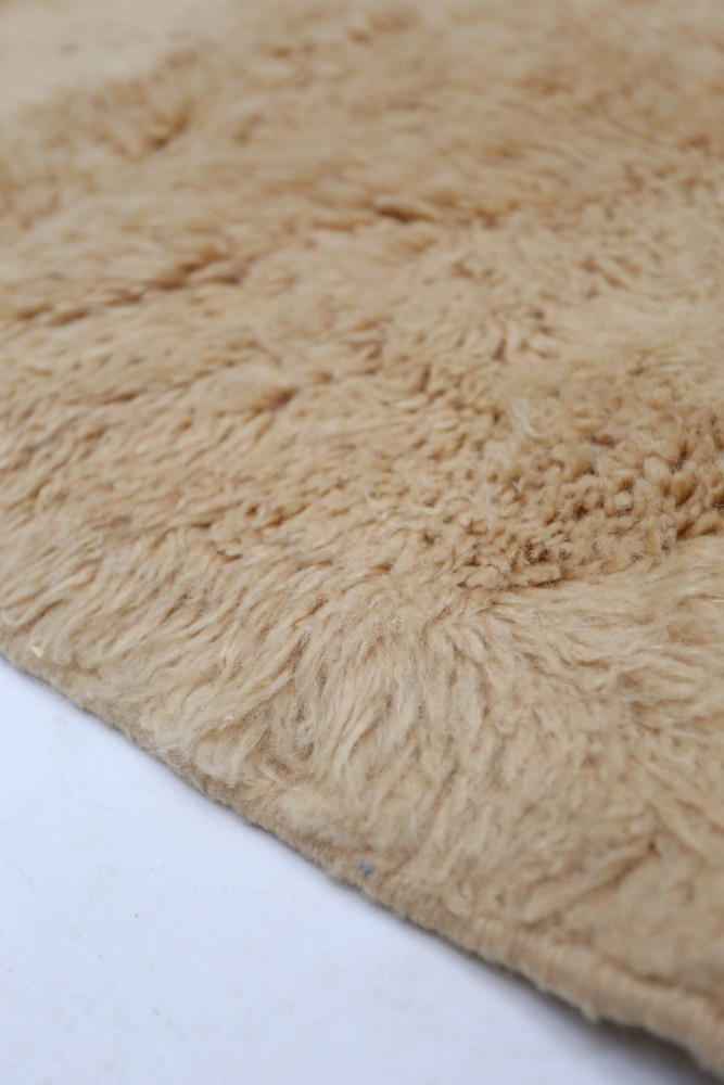 Tapis berbère en laine beige, au design doux et texturé, ajoutant chaleur et confort à votre intérieur.