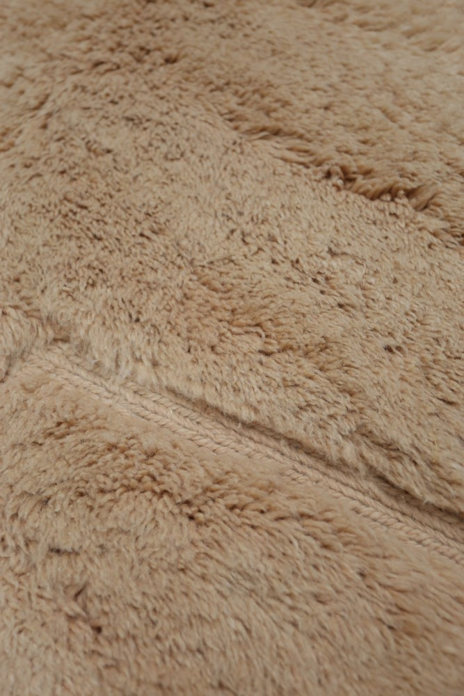 Tapis berbère au style moderne, couleur beige doux avec texture pelucheuse et motifs subtils pour un intérieur chaleureux.