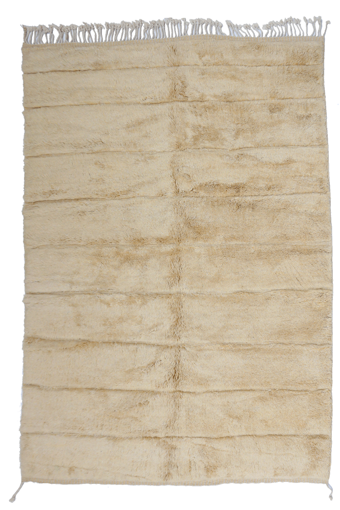 Tapis berbère doux en couleur beige clair avec des motifs linéaires discrets et des franges en coton.