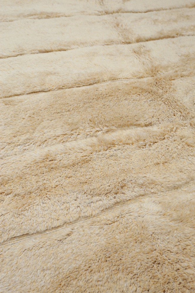 Tapis berbère en laine beige, au design doux et texturé, apportant chaleur et élégance à votre intérieur.