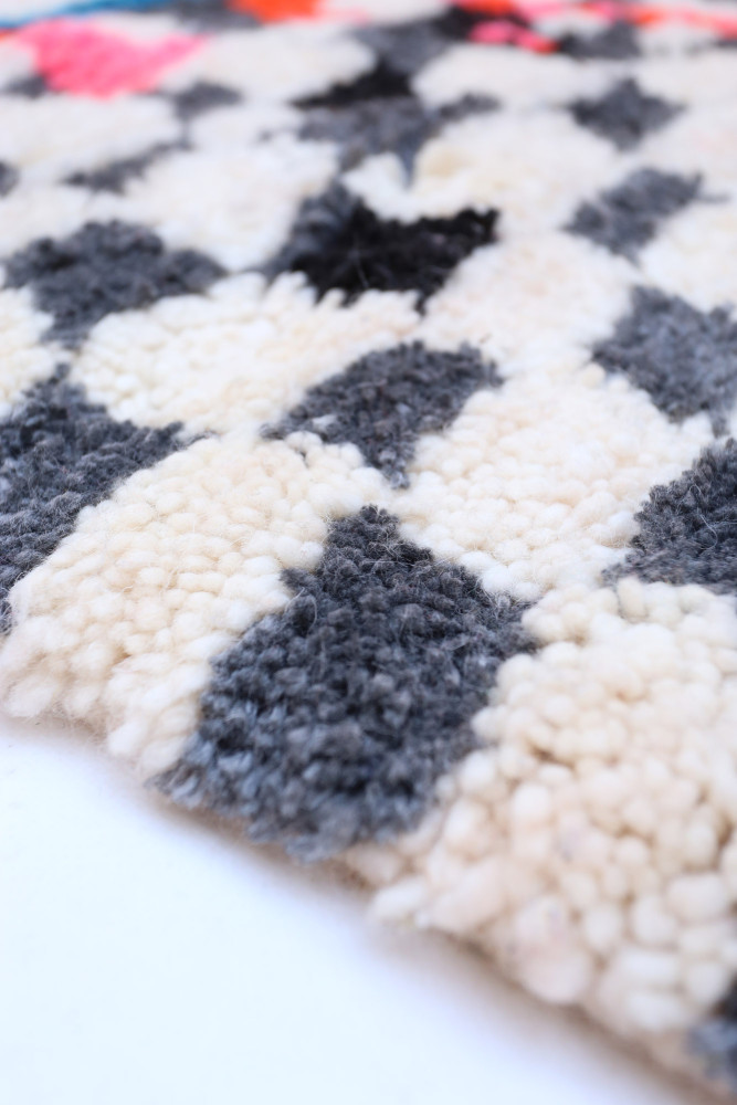 Tapis berbère en motifs géométriques avec du noir, gris et crème, ajoutant une touche moderne et artisanale à votre intérieur.