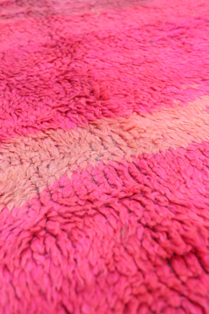 Tapis berbère au style moderne, aux nuances de rose vibrant et motifs abstractés, idéal pour égayer votre intérieur.
