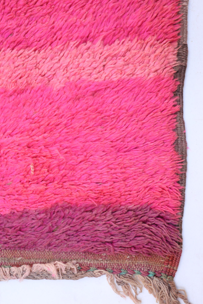 Tapis berbère aux teintes roses dégradées, à la texture douce et aux motifs minimalistes pour un style moderne et chaleureux.