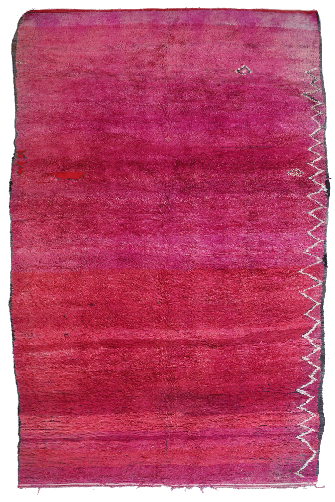 Tapis berbère aux dégradés de rose et motifs géométriques en blanc, élégant et traditionnel pour un intérieur moderne.
