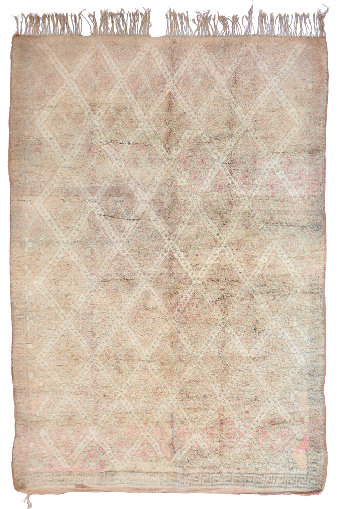 Tapis berbère aux motifs géométriques en tons beiges et roses, offrant une ambiance chaleureuse et authentique.