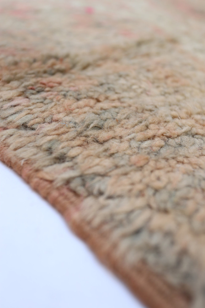 Tapis berbère aux teintes douces, motifs subtils et texture laineuse, parfait pour un intérieur chaleureux.