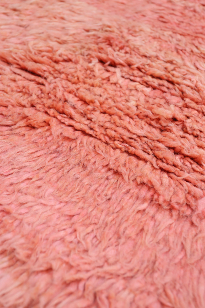 Tapis berbère en laine rose avec des textures délicates et un motif minimaliste, ajoutant une touche chaleureuse et moderne.