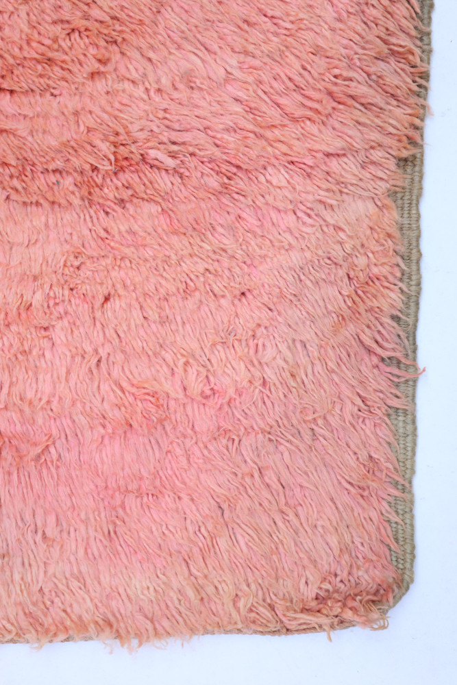 Tapis berbère en laine aux teintes roses douces et textures douillettes, parfait pour un décor chaleureux et moderne.