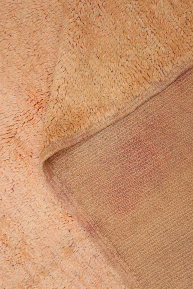 Tapis berbère en teintes chaudes avec un motif texturé et doux, idéal pour un intérieur confortable et accueillant.