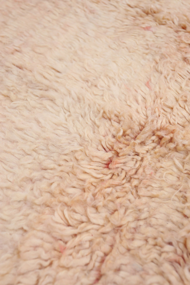 Tapis berbère artisanal, aux teintes douces et motifs texturés, parfait pour une décoration chaleureuse et élégante.